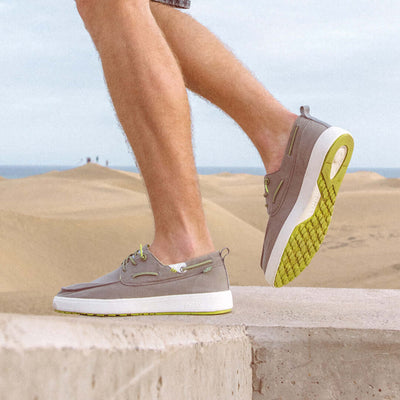 Person wearing Maui Hi-Grip Boat Shoes with yellow contrast outsole, showcasing style and comfort in a desert landscape.