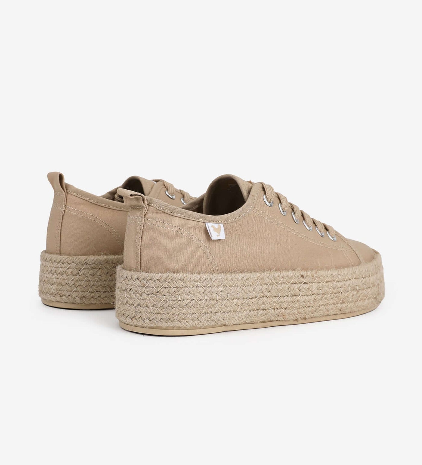 Beige lace-up platform espadrille sneakers with jute band and rubber sole, showcasing a relaxed Mediterranean style.