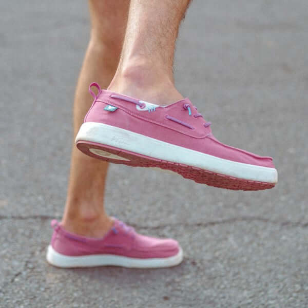 Man wearing pink Maui Hi-Grip Boat Shoes with elastic laces and contrast rubber outsole on a concrete surface.